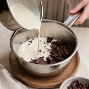 Zašľahávanie ganache do mäkkého masla na čokoládový krém.