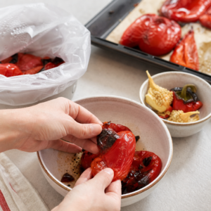 Upečená paprika po zaparení a ošúpaní, pripravená na odkvapkanie.