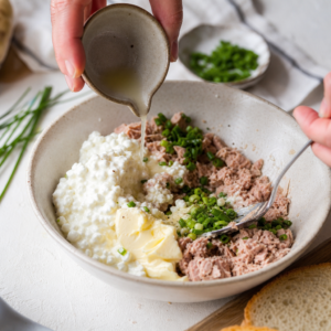 Tuniak, cottage cheese, citrón a pažítka v mise pred zmiešaním.