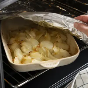 Biela fazuľa, pečená cibuľa a maslo pripravené v nádobe na mixovanie.